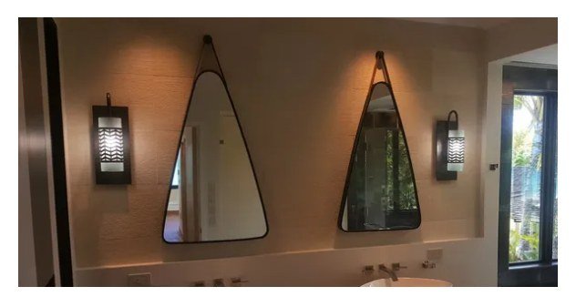Triangular-framed mirrors flanked by matching wall sconces