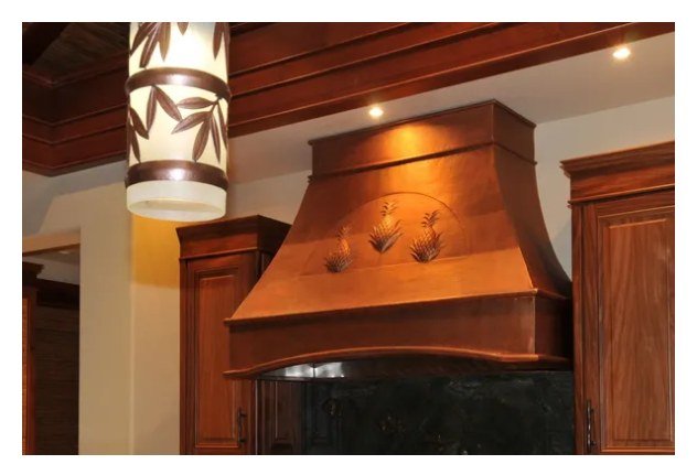 Custom hammered copper oven hood over a kitchen island